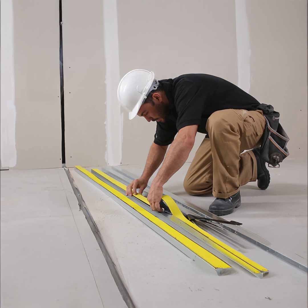 A photo of a man using the product DANOSA FONODAN 70mm Tape – 1000 cm × 6.6 cm in the appropriate application.